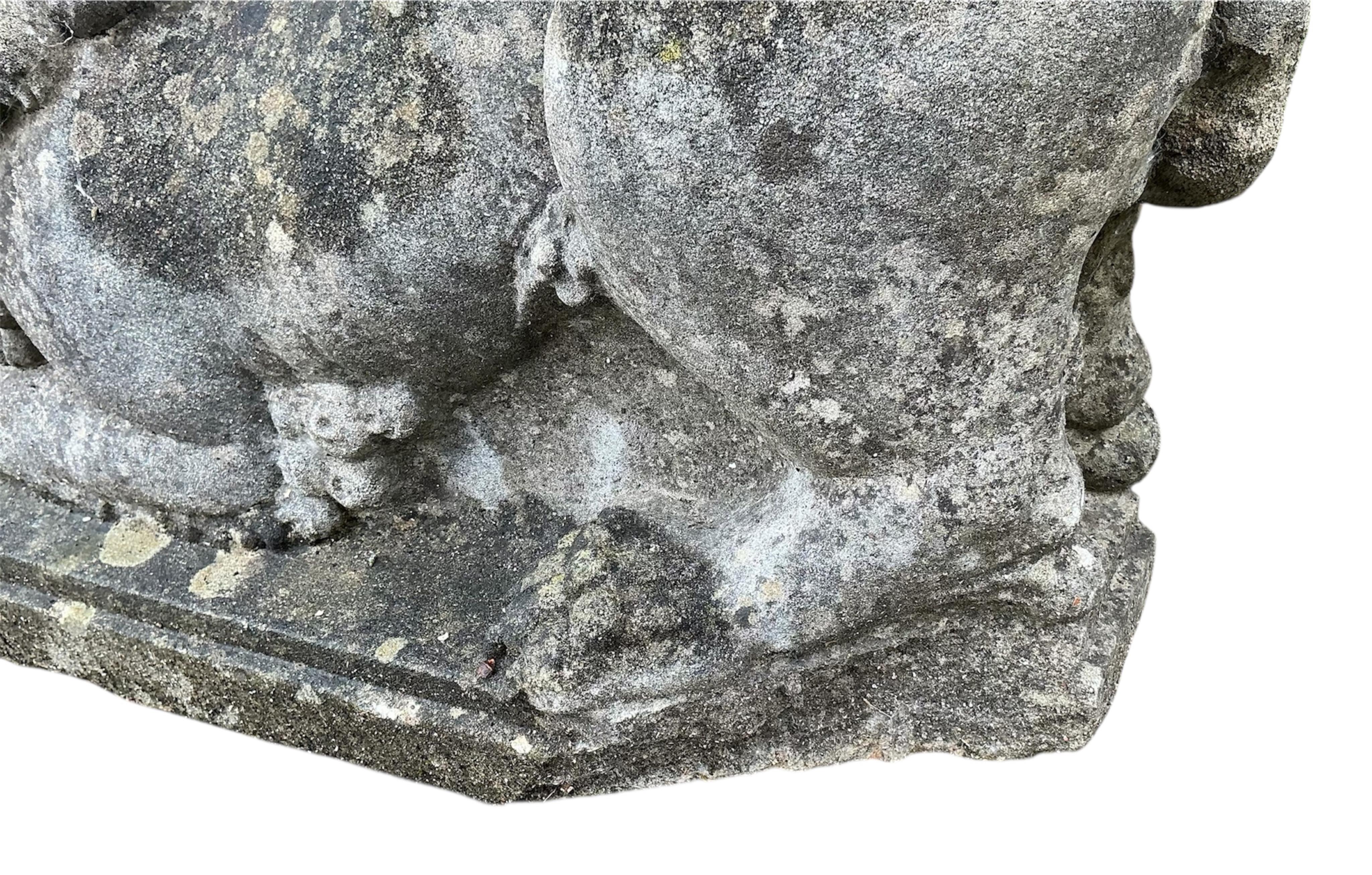 A reconstituted stone recumbent lion and ram garden ornament, length 60cm, together with a painted composition lion mask wall fountain